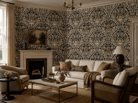 An elegant living room featuring a classic damask wallpaper with a beige, gold, and dark gray pattern. The room is furnished with a cream sofa, two matching armchairs, a wooden coffee table, and a white fireplace mantel.