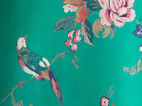 Upclose detailing of beautiful, colorful birds and luscious flowers on a peel and stick green wallpaper